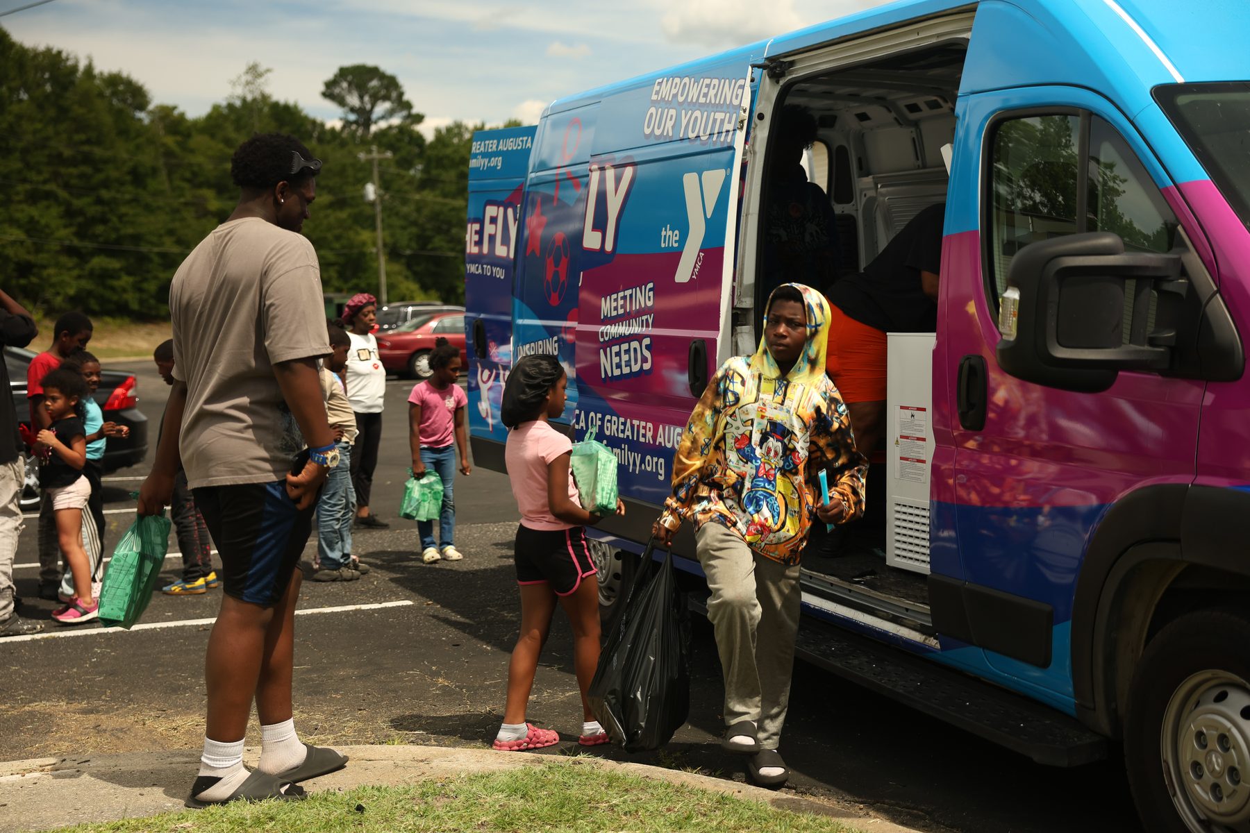 A child stepping out of the Y on the Fly van with supplies