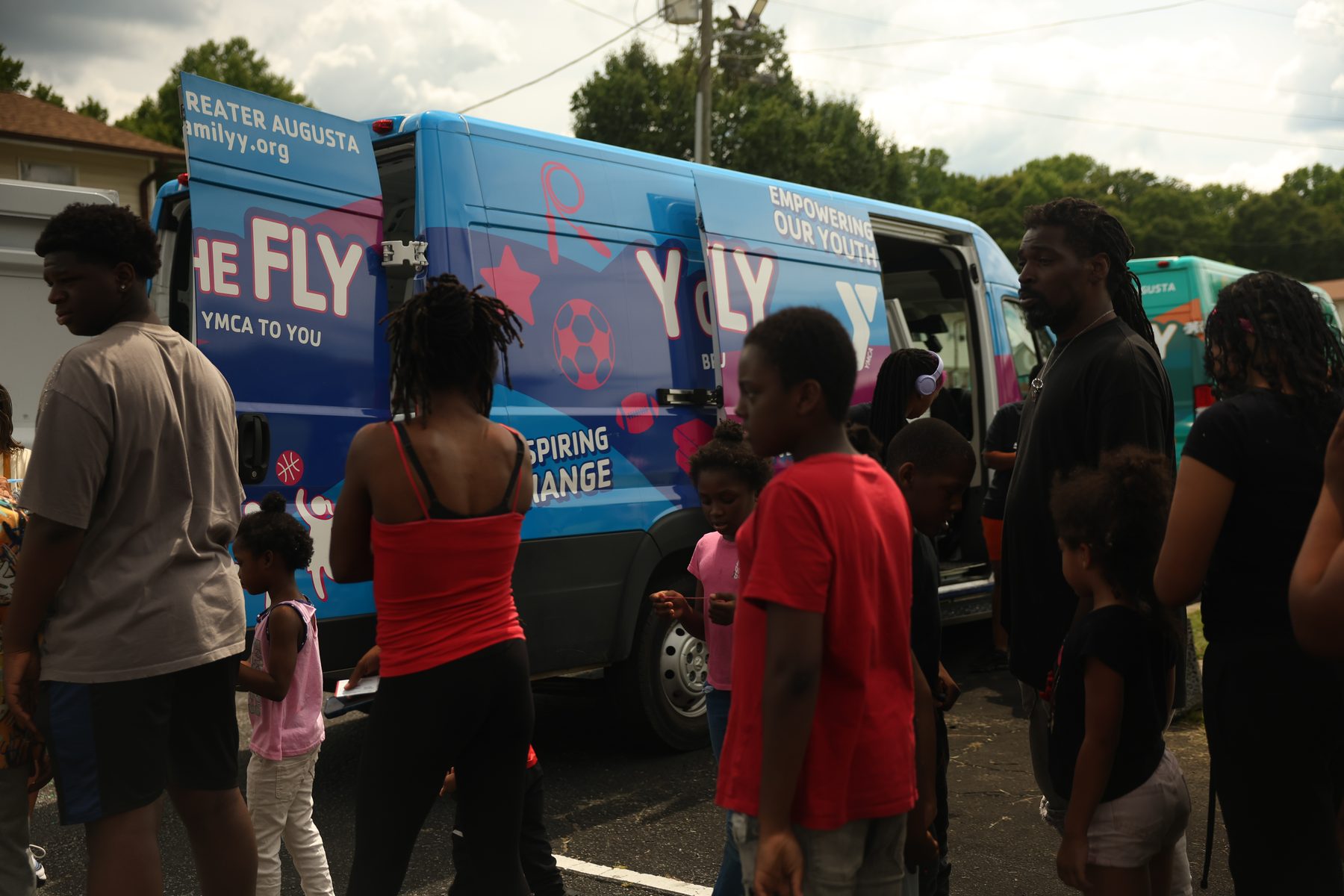 Families and children beside the Y on the Fly van